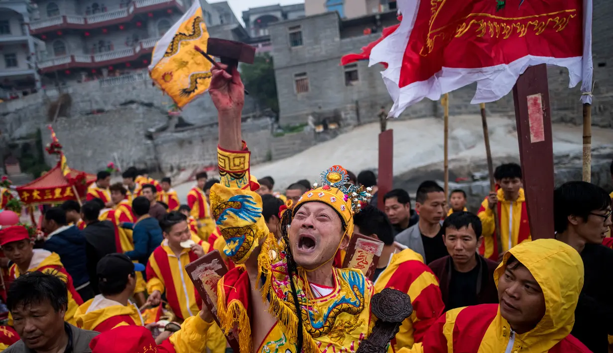 Seorang pria berpakaian seperti Dewa Laut melakukan prosesi ritual di pantai desa Fuye, Provinsi Fujian, Tiongkok (5/3). Nama festival atau ritual ini adalah "The Dash of the Ocean Gods". (AFP Photo/Johannes Eisele)