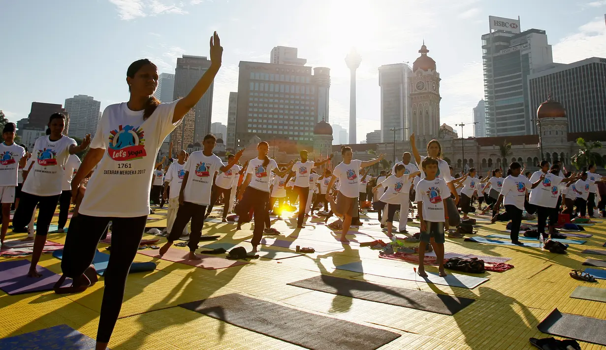 Sejumlah peserta melakukan gerakan yoga saat berlatih di Lapangan Independen di Kuala Lumpur, Malaysia (2/7). Acara ini juga bertujuan untuk memecahkan rekor Malaysia Book of Records untuk pertemuan yoga terbesar di Malaysia. (AP Photo / Daniel Chan)