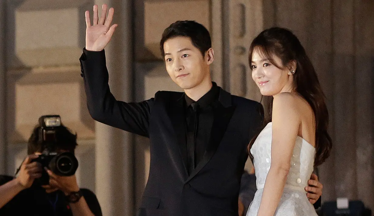 Song Joong Ki dan Song Hye Kyo melambaikan tangan ketika berpose di karpet merah The 52nd Baeksang Art Awards, Seoul, 3 Juni 2016. Rencana pernikahan dua bintang Korea Selatan itu memuncaki trending topic dengan tagar Song Song Couple. (AP/Ahn Young-joon)