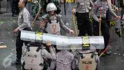 Hujan yang mengguyur di Ibukota tidak menyurutkan petugas kepolisian untuk tetap menjaga aksi Hari Buruh di Jalan Medan Merdeka, Jakarta, Senin (1/5). (Liputan6.com/ Yoppy Renato)