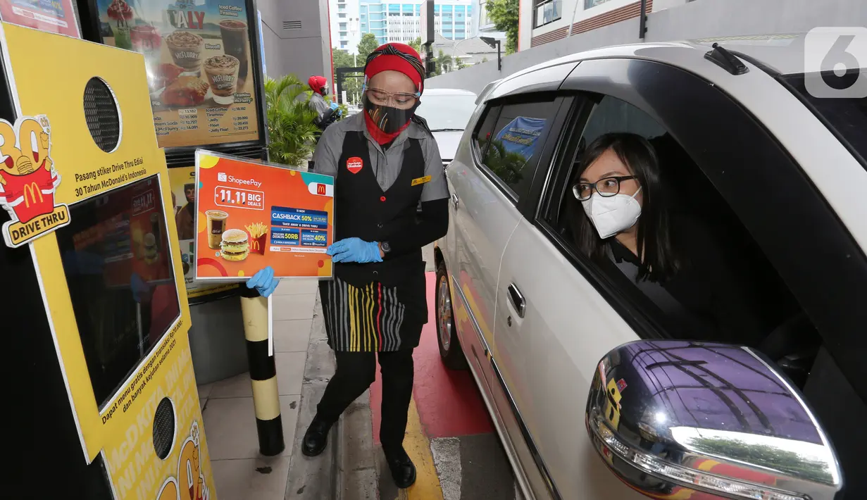 Pramusaji menawarkan menu dalam promo Cashback 50% dan Diskon 50.000 dari ShopeePay di drive thru gerai McDonald’s Salemba, Jakarta, Kamis (11/11/2021). Kolaborasi kali kedua antara ShopeePay dan McDonald’s Indonesia meningkat hingga 2 kali lipat dalam satu tahun. (Liputan6.com/Fery Pradolo)