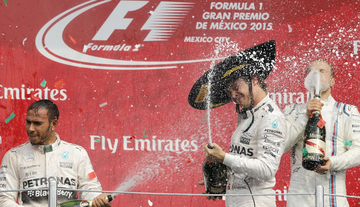 Dua pebalap Mercedes saling semprotkan sampanye di podium juara F1 GP Meksiko di Sirkuit Autodromo Hermanos Rodriguez, Senin (2/11/2015) dini hari WIB. (EPA/Ulises Ruiz Basurto)