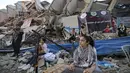 Seorang gadis Palestina memainkan alat musik saat tampil di puing-puing Menara Hanadi di Kota Gaza (2/6/2021). Acara diselenggarakan oleh Komite Pemuda dan Kebudayaan Palestina lebih dari seminggu setelah gencatan senjata mengakhiri 11 hari permusuhan antara Israel dan Hamas. (AFP Photo/Mohammed Abe