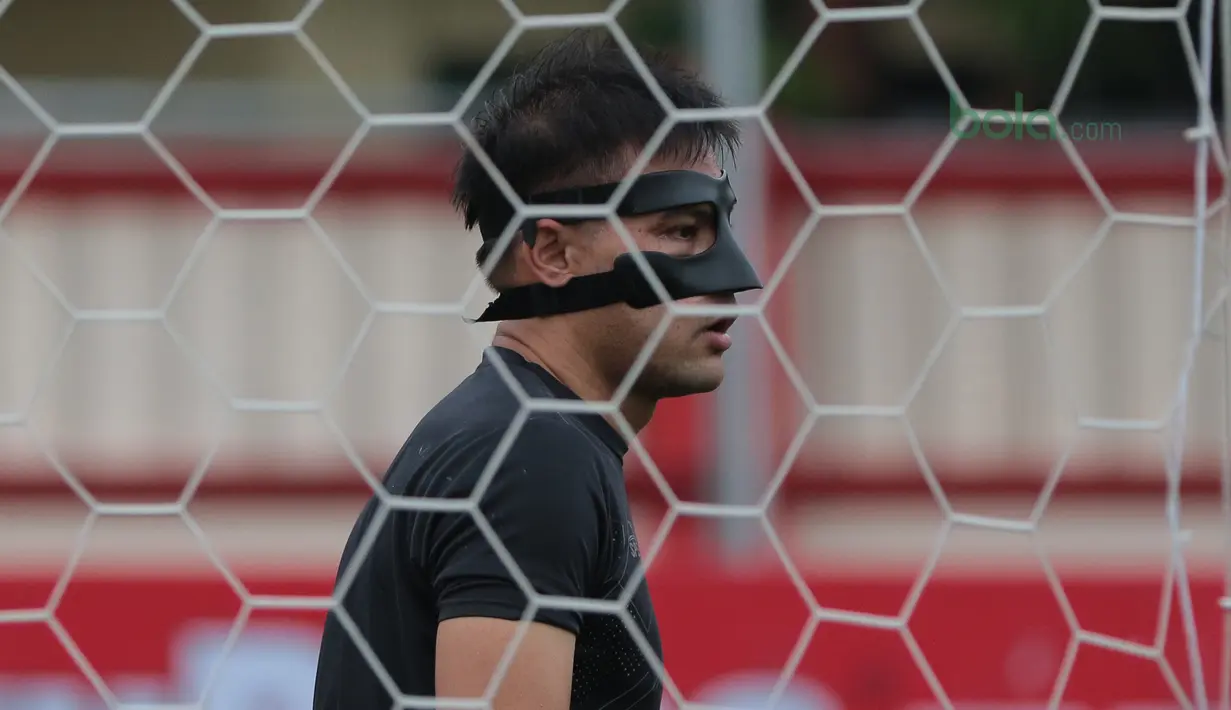 Andritany menggunakan masker pelindung wajah saat sesi latihan tim jelang laga Gojek Liga 1 bersama Bukalapak di Stadion PTIK, Jakarta, Senin (25/6/2018). Andritany berpeluang tampil saat Persija melawan Persebaya. (Bola.com/Nick Hanoatubun)