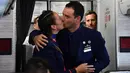 Pasangan pramugari Paula Podest dan Carlos Ciuffardi berciuman usai dinikahkan Paus Fransiskus di atas pesawat selama penerbangan di antara Santiago dan kota utara Iquique (18/1). (AFP Photo/Vincenzo Pinto)