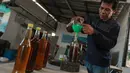 Pengurus RW 01 menuangkan bahan bakar alternatif sejenis petasol kedalam botol hasil dari proses pengolahan sampah plastik di Jakarta, Senin (19/10/2026). (KLY/Budy Santoso)