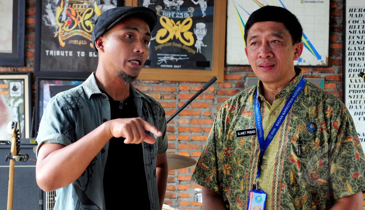 Ivan Slank (kiri) dan Kepala Humas BNN, Kombes Pol Slamet Pribadi (kanan) saat manyambangi markas grup Band Slank di Gang Potlot, Jakarta, Selasa (17/3/2015). Kedatangan BNN untuk berdiskusi tentang Indonesia Darurat Narkoba. (Liputan6.com/Yoppy Renato)