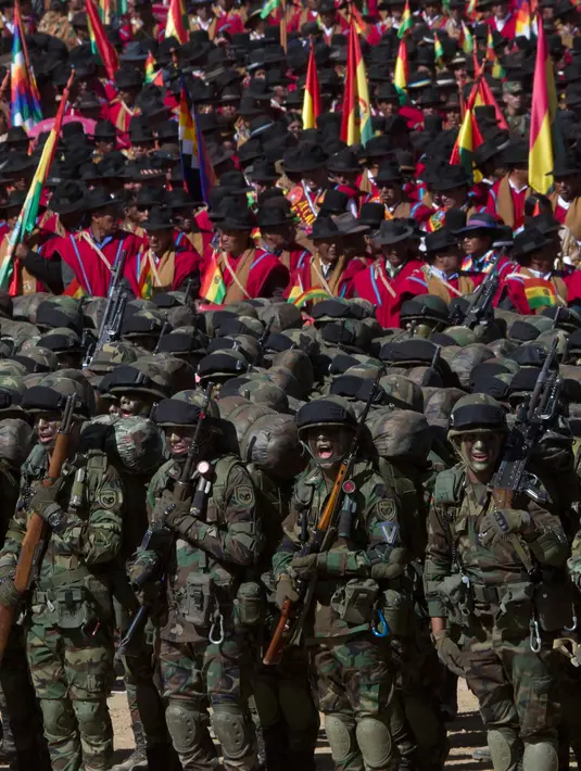 Tentara dan suku pribumi Aymara berbaris saat mengikuti upacara ulang tahun tentara Bolivia ke-192 di Kjasina, Bolivia (7/8). Upacara ini digelar ditengah gurun karena ingin melibatkan penduduk pribumi asli Bolivia. (AP Photo/Juan Karita)