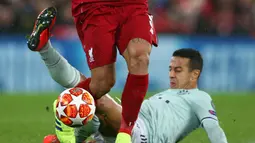 Gelandang Liverpool Roberto Firmino melewati pemain tengah Bayern Munchen Thiago Alcantara pada leg pertama babak 16 besar Liga Champions di Anfield, Liverpool, Inggris, Selasa (19/2). Pertandingan berakhir 0-0. (AP Photo/Dave Thompson)