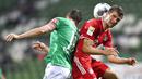 Penyerang Bayern Munchen, Thomas Mueller, duel udara dengan pemain Werder Bremen pada laga Bundesliga di Weserstadion, Bremen, Selasa (16/6/2020). Bayern Munchen menang dengan skor 1-0 atas Werder Bremen. (AP/Martin Meissner)