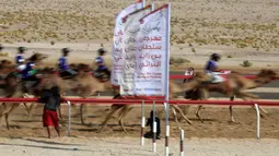 Para joki memacu untanya dalam balap unta selama festival warisan Sheikh Sultan Bin Zayed al-Nahyan di Abu Dhabi, Uni Emirat Arab (10/2). (AFP/Karim Sahib)