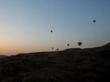 Sejumlah balon udara yang membawa wisatawan terbang saat matahari terbit di atas kota Luxor, Kairo, Mesir (13/12). Luxor adalah sebuah kota modern yang terletak di kedua tepi timur dan barat Sungai Nil di Mesir bagian utara. (Reuters/Amr Abdallah Dalsh)