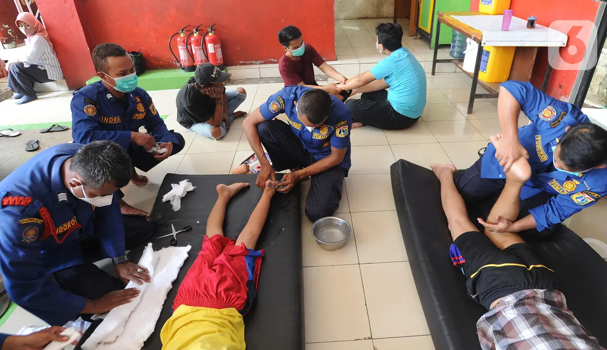 Para petugas Damkar mengobati warga yang mengalami patah tulang di Pos Damkar Ciganjur, Jagakarsa, Jakarta Selatan, Rabu (2/12/2020). Petugas Damkar memijat khas Cimande dengan bayaran seikhlasnya, pengobatan dilakukan di sela waktu senggang petugas Damkar. (merdeka.com/Arie Basuki)