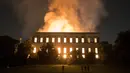 Warga menyaksikan kebakaran yang melanda Museum Nasional Brasil berusia 200 tahun di Rio de Janeiro, Minggu (2/9). Museum itu didirikan pada 1818 oleh Raja Joao VI dan merupakan salah satu museum terpenting di Brasil. (AP/Leo Correa)