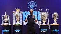 Mantan pemain Manchester City, Shaun Wright-Phillips, berfoto di depan empat trofi yang diraih The Citizen musim lalu. Trofi tersebut dipamerkan di hadapan media, di Hotel Double Three Jakarta, Indonesia, Kamis (28/9/2023). (Bola.com/M Iqbal Ichsan)