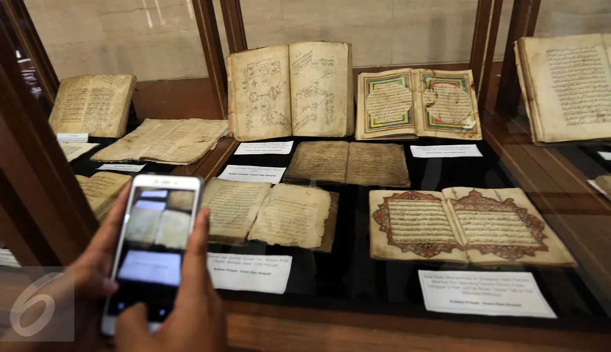 Pengunjung mengambil gambar sejumlah kitab yang dipajang saat pameran di Gedung PBNU, Jakarta, Senin (30/1). Pameran tersebut digelar dalam rangka Harlah NU ke-91. (Liputan6.com/Johan Tallo)