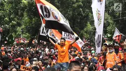 Jakmania mengibarkan bendera Persija saat penyerahan piala Liga I di depan Balai Kota, Jakarta, Sabtu (15/12). Persija kembali meraih juara Liga Indonesia setelah 17 tahun. (Liputan6.com/Herman Zakharia)