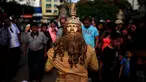Seorang kontestan beraksi saat mengikuti kontes patung di pusat kota San Salvador , El Salvador, (18/6). Kontes ini menjadi tontonan warga El Savador yang sedang melintas. (REUTERS / Jose Cabezas)