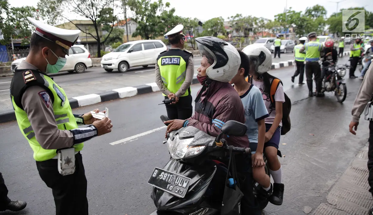 Anggota Polantas memeriksa surat kelengkapan pengendara motor saat Operasi Zebra Jaya di jalan Letjen Suprapto, Jakarta, Selasa (7/11). (Liputan6.com/Faizal Fanani)