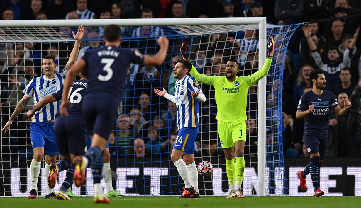 Manchester City sudah unggul 1-0 pada menit ke-13. Sepakan Ilkay Guendogan (kanan) usai meneruskan bola liar dari Bernardo Silva tidak mampu dihalau kiper Brighton, Robert Sanchez. (AFP/Glyn Kirk)