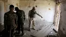 Sejumlah tentara Irak memeriksa sebuah bangunan yang diyakini bekas persembunyian ISIS di sebuah desa di Mahana, Mosul, Irak, Kamis (28/4). Tentara Irak berhasil mengalahkan Militan ISIS yang menguasai Mosul sejak Juni 2014. (REUTERS/Goran Tomasevic) 