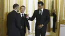 Pemain PSG, Kylian Mbappe (kiri) bersalaman dengan Emir Qatar, Sheikh Tamin bin Hamad Al-Thani (kanan) dan Presiden Prancis, Emmanuel Macron (tengah) saat diundang menjadi salah satu tamu di Istana Elysee, Prancis, Selasa (27/2) malam waktu setempat. (AFP/Pool/Yoan Valat)