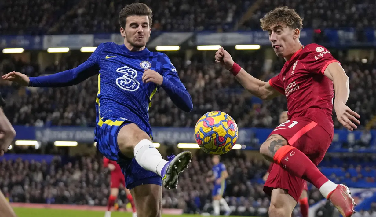 Bek Liverpool Kostas Tsimikas berebut bola dengan gelandang Chelsea Mason Mount pada pekan ke-21 Liga Inggris di Stamford Bridge, London, Minggu (2/1/2022) malam WIB. Duel Chelsea vs Liverpool berakhir imbang dengan skor akhir 2-2. (AP Photo/Matt Dunham)