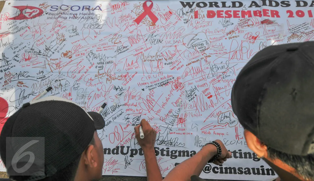 Sejumlah warga menandatangani petisi Peduli HIV/AIDS di kawasan Bundaran HI saat Car Free Day, Jakarta, Minggu (13/12/2015). Kegiatan tersebut dalam rangka memperingati hari AIDS sedunia. (Liputan6.com/Yoppy Renato)