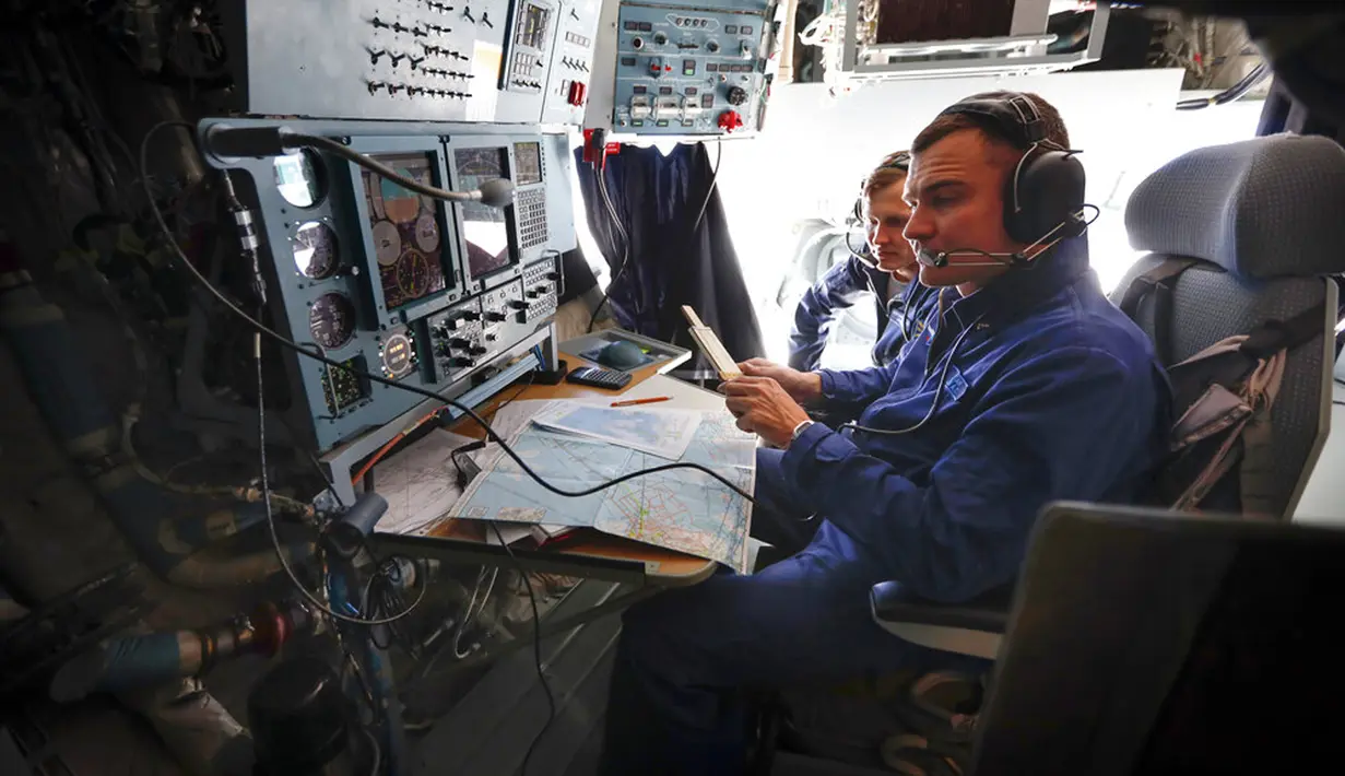 Anggota awak pesawat kargo militer Rusia Il-76 bekerja selama penerbangan ke Pulau Alexandra Land di Kepulauan Franz Josef Land, Rusia, Senin (17/5/2021). Pangkalan militer ini dipenuhi rudal dan radar serta landasan pacu yang dapat menangani semua jenis pesawat. (AP Photo/Alexander Zemlianichenko)