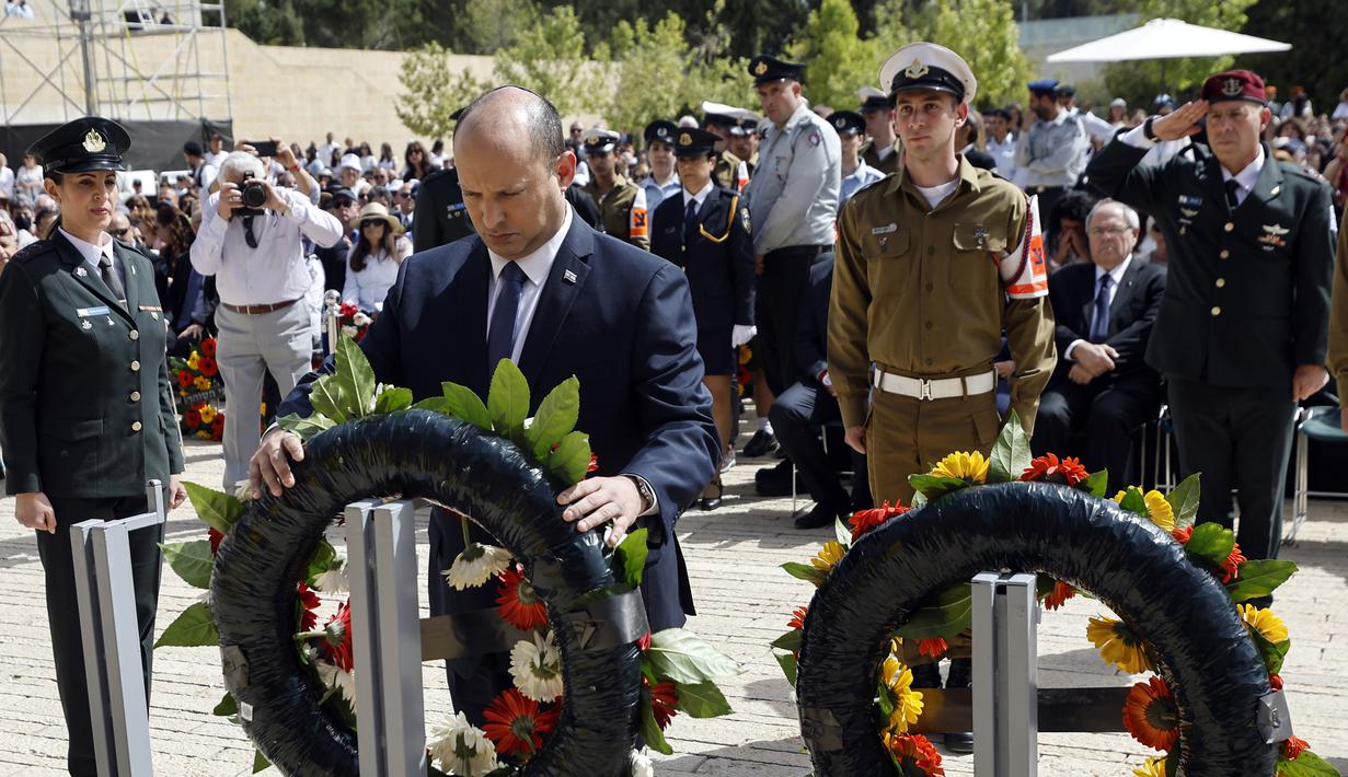 <p>Perdana Menteri Israel Naftali Bennett memberikan penghormatan saat upacara peletakan karangan bunga menandai Hari Peringatan Holocaust di Warsaw Ghetto Square, Yad Vashem, Yerusalem, Israel, 28 April 2022. (Amir Cohen/Pool Photo via AP)</p>