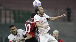 Bek Cagliari, Diego Godin menyundul bola saat berebut bola dengan gelandang AC Milan, Hakan Calhanoglu  pada pekan ke-37 Serie A di San Siro, Senin (17/5/2021) dini hari WIB.  AC Milan gagal menjauh di klasemen Liga Italia usai imbang 0-0 lawan Cagliari. (AP Photo/Luca Bruno)