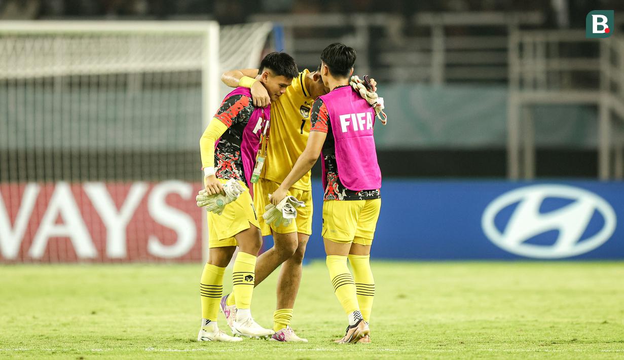 Kiper Timnas Indonesia U-17, Ikram Algiffari (tengah) berpelukan dengan dua kiper cadangan setelah berakhirnya laga menghadapi Timnas Ekuador U-17 pada laga pertama Grup A Piala Dunia U-17 2023 di Stadion Gelora Bung Tomo, Surabaya, Jumat (10/11/2023). (Bola.com/Bagaskara Lazuardi)