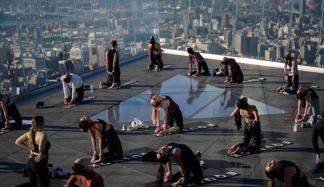 Praktisi yoga menghadiri kelas di Edge Observation Deck, Manhattan, New York, Amerika Serikat, Kamis (17/6/2021). Di tempat ini, para praktisi bisa berlatih yoga sambil menghadap cakrawala. (Ed JONES/AFP)