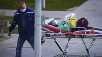 Pekerja medis membawa pasien yang diduga terinfeksi COVID-19 dengan tandu di sebuah rumah sakit di Kommunarka, Moskow, Senin (11/10/2021). Infeksi dan kematian virus Corona harian Rusia kembali melonjak mendekati level tertinggi yang pernah tercatat di negara ini. (AP Photo/Alexander Zemlianichenko)