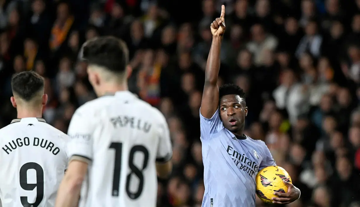 Penyerang Real Madrid, Vinicius Junior (kanan) merayakan gol pertama timnya saat pertandingan sepak bola Liga Spanyol melawan Valencia CF di Stadion Mestalla, Valencia, 2 Maret 2024 (Jose Jordan/AFP)