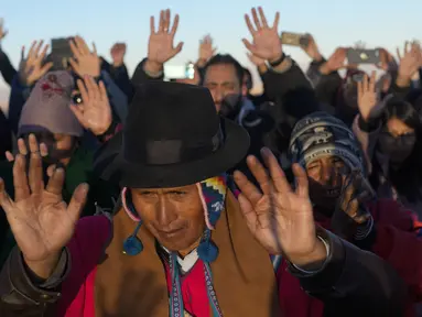 Masyarakat Adat Aymara menerima sinar matahari pertama dalam ritual Tahun Baru di gunung suci Apacheta Murmutani di pinggiran Hampaturi, Bolivia, Rabu dini hari, 21 Juni 2023. (AP Photo/Juan Karita)