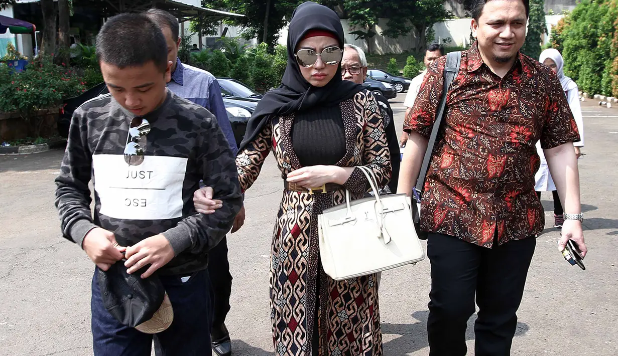 Bella tiba di Pengadilan sekitar pukul 11.45 WIB dengan mengendarai mobil Alphard. Dengan mengenakan hijab warna hitam dan busana terusan panjang batik dan kaca mata warna gelap. Tidak lama setelah itu, azan berkumandang. (Deki Prayoga/Bintang.com)
