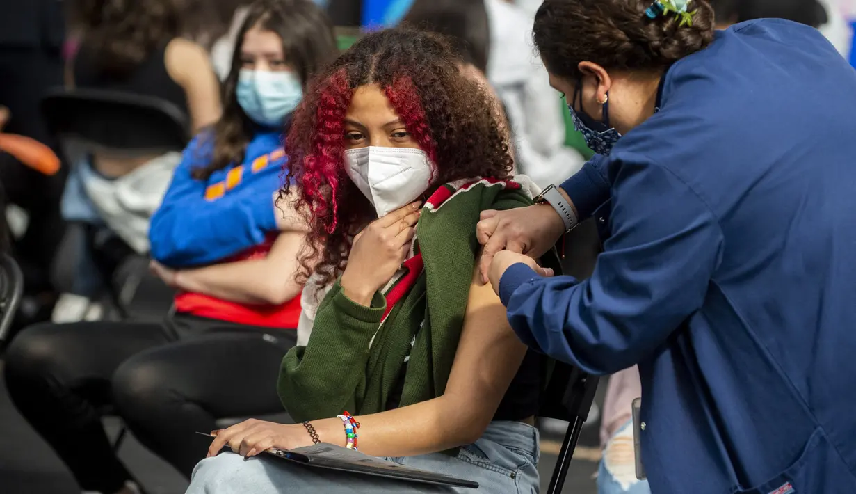 Seorang perawat menyuntik seorang remaja wanita dengan dosis booster vaksin Pfizer terhadap COVID-19 di Mexico City (9/2/2022). Menteri kesehatan Meksiko melaporkan 9.242 kasus baru COVID-19 dan 206 kematian pada Senin (7/2/2022). (AFP/Claudio Cruz)