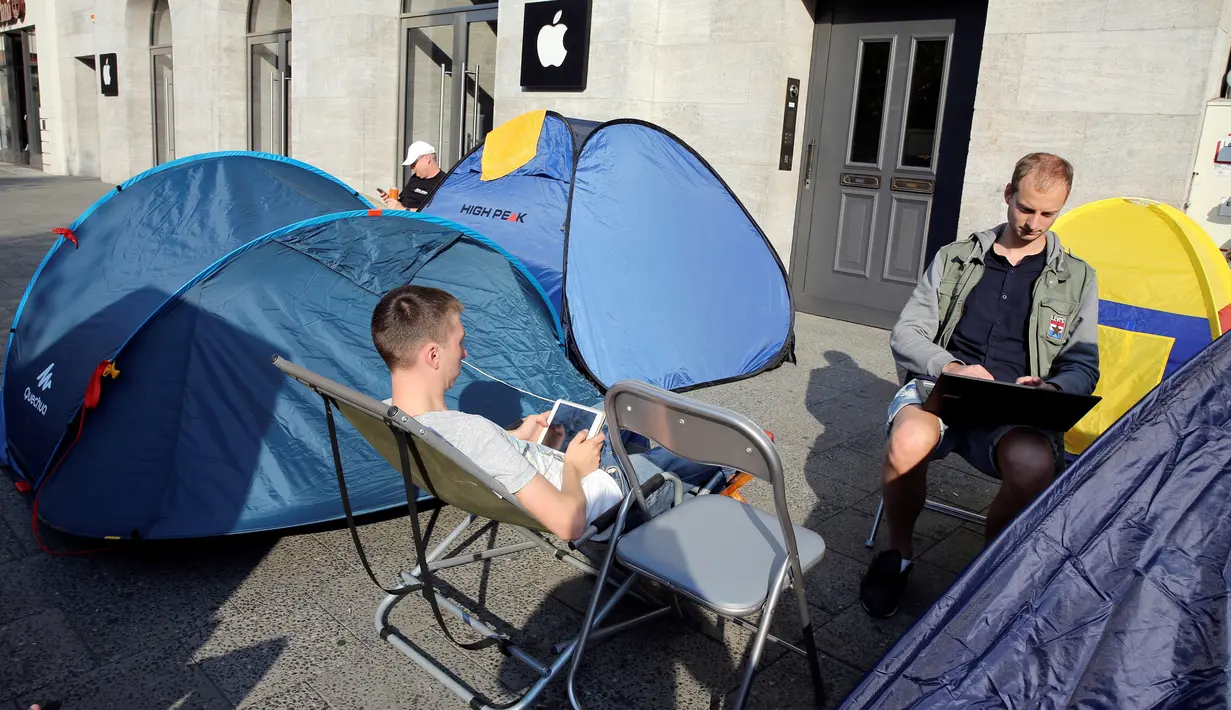 Pecinta iPhone dari Belarus rela antre di samping tenda sambil bermain tablet dan laptop untuk membeli iPhone Apple 7 yang baru dirilis di depan toko Apple Berlin, Jerman (12/09). Mereka rela menginap untuk mendapatkan iPhone. (REUTERS/Fabrizio Bensch)