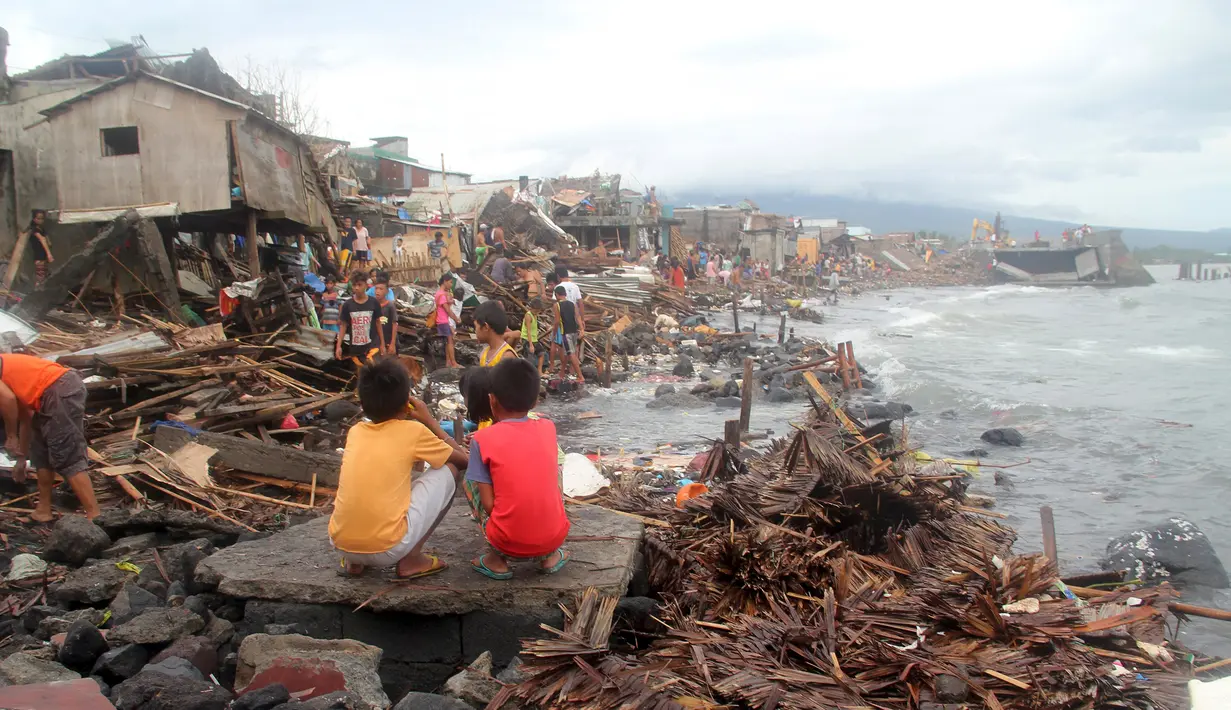 Warga berada diluar rumah pasca terkena Topan Melor di desa Pigcale, Legazpi, provinsi Albay, Filipina (15/12). Dasyat Topan Melor menyebabkan banjir, badai 800.000 orang dievakuasi dari Filipina tengah. (REUTERS/Rhaydz Barcia)