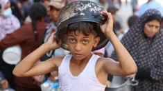 Seorang anak laki-laki Palestina mengantri untuk menerima jatah makanan, yang ditawarkan oleh sebuah badan amal, di kamp pengungsi Al-Shati di Gaza pada 17 Oktober 2024. (Omar AL-QATTAA/AFP)