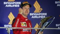 Pembalap Ferrari Sebastian Vettel berselebrasi di podium setelah memenangkan balapan Formula Satu (F1) Grand Prix Singapura di Sirkuit Jalan Marina Bay, Singapura (22/9/2019). Vettel berhasil menjuarai balapan dengan catatan waktu 1 jam:58menit:33.667 detik. (AP Photo/Vincent Thian)