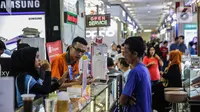 Petugas toko smartphone berbincang dengan calon pembeli di ITC Roxy Mas, Jakarta, Selasa (26/11/2019). Penurunan penjualan smartphone pada kuartal II tahun 2019 mencapai 1,7 persen secara year over year atau menurun dari angka 374 juta unit menjadi 368 juta. (Liputan6.com/Faizal Fanani)