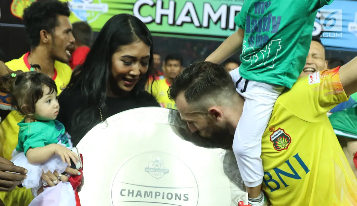 Pemain depan Bhayangkara FC, Ilija Spasojevic mencium piala Liga 1 Indonesia usai melawan Persija di Stadion Patriot Candrabhaga, Bekasi, Minggu (12/11). Bhayangkara FC meraih 68 poin dari 34 pertandingan. (Liputan6.com/Helmi Fithriansyah)