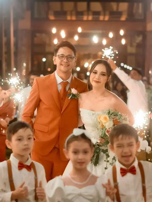 Di sampingnya, terlihat Zarry yang tampil gagah mengenakan setelan jas, vest, dan dasi berwarna oranye yang cerah di atas kemeja warna putih.  [@loka.mata]