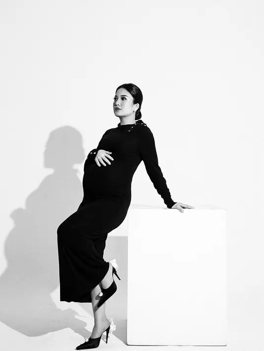 Valencia tampil cantik menawan mengenakan dress simple warna hitam. Berpose sambil memegang perutnya yang makin besar. [Instagram/valenciatanoe]