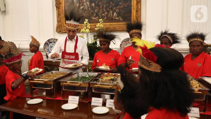 Presiden Joko Widodo atau Jokowi mengajak makan perwakilan anak-anak sekolah dasar dari Papua di Istana Merdeka, Jakarta, Jumat (11/10/2019). Perwakilan anak-anak sekolah dasar dari Papua kompak menggunakan baju merah dan topi rumbai. (Liputan6.com/Angga Yuniar)