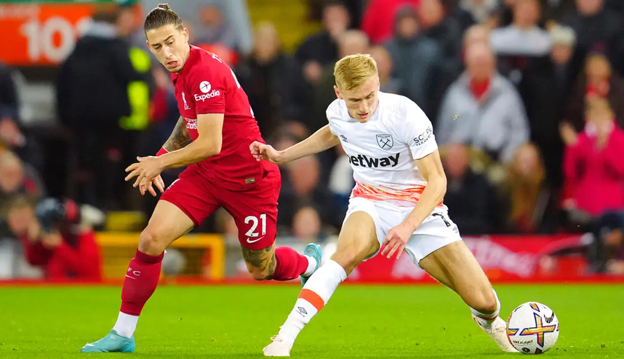 Pemain West Ham United Flynn Downes (kanan) berebut bola dengan pemain Liverpool Kostas Tsimikas pada pertandingan sepak bola Liga Inggris di Stadion Anfield, Liverpool, Inggris, 19 Oktober 2022. Liverpool mengalahkan West Ham United dengan skor 1-0. (AP Photo/Jon Super)