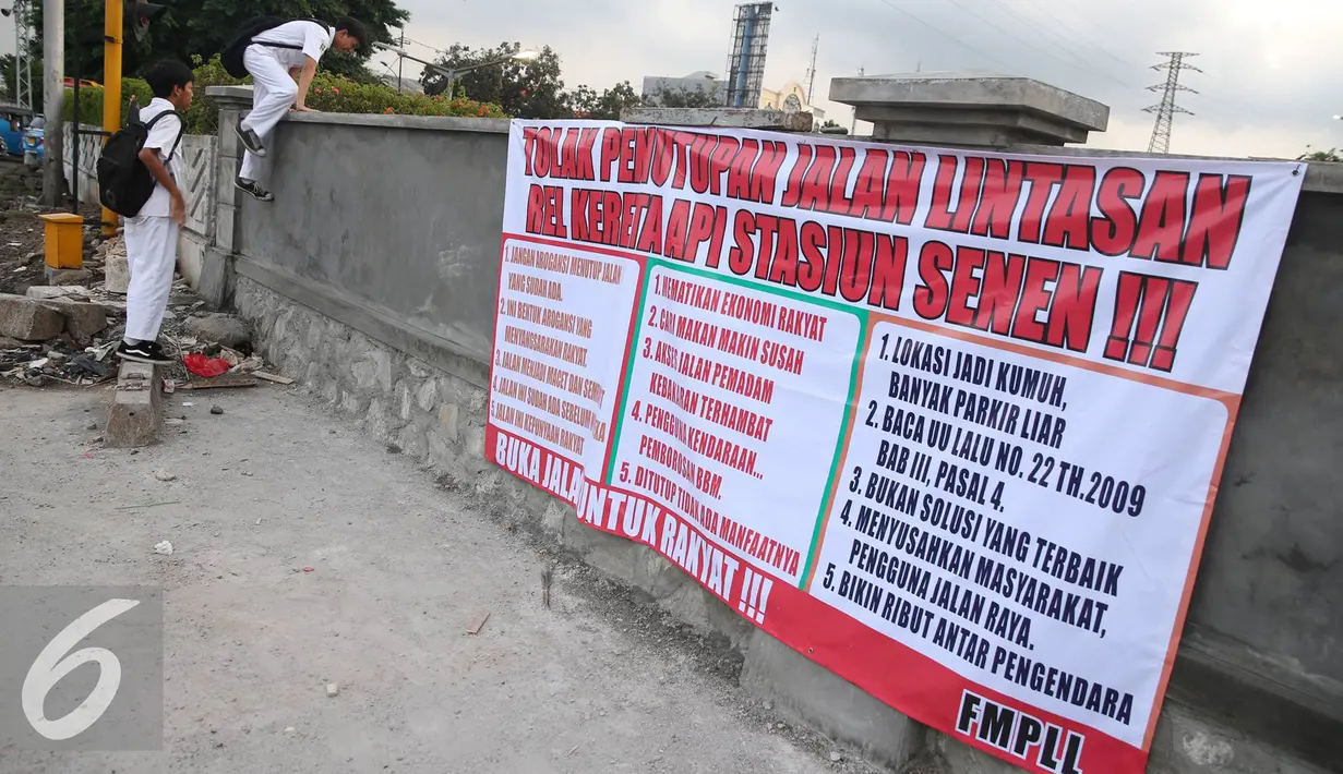 Spanduk tolak penutupan jalan terpampang di perlintasan kereta Stasiun Senen, Jakarta, Senin (28/11). Warga menolak penutupan jalan di kawasan tersebut karena dianggap menambah kemacetan serta mematikan perekonomian. (Liputan6.com/Immanuel Antonius)