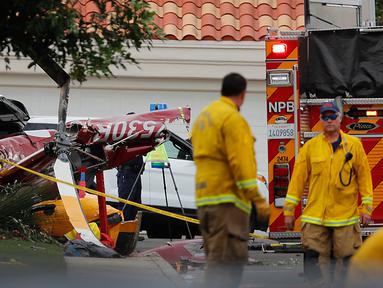 Polisi menyelidiki helikopter yang jatuh menghantam sebuah rumah di Newport Beach, California, Selasa (30/1). Lima orang terlibat kecelakaan termasuk empat orang yang berada di helikopter dan satu pejalan kaki. (Allen J. Schaben/Los Angeles Times via AP)